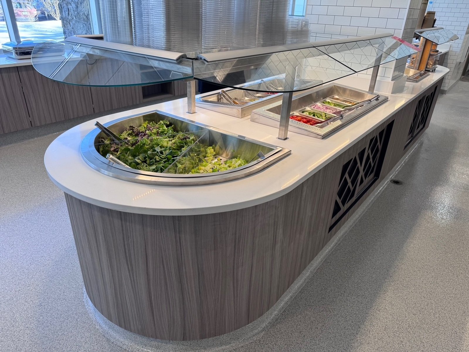 Corporate dining cafe salad bar with refrigerated wells and glass sneeze guard